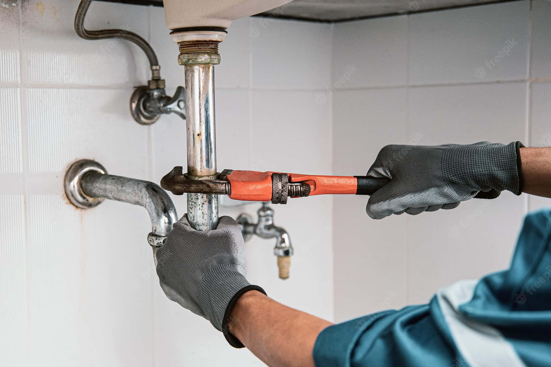 Plumber working on pipes in a London kitchen